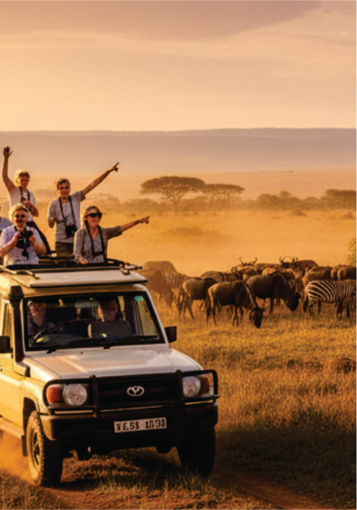 People on a land cruiser safari journey with wildlife in the Masai Mara, Kenya.