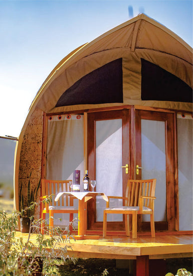 Beautiful view of wine table setting on wooden verandah near in tented camp with beige canvas on 2 nights Masai Mara budget accommodation